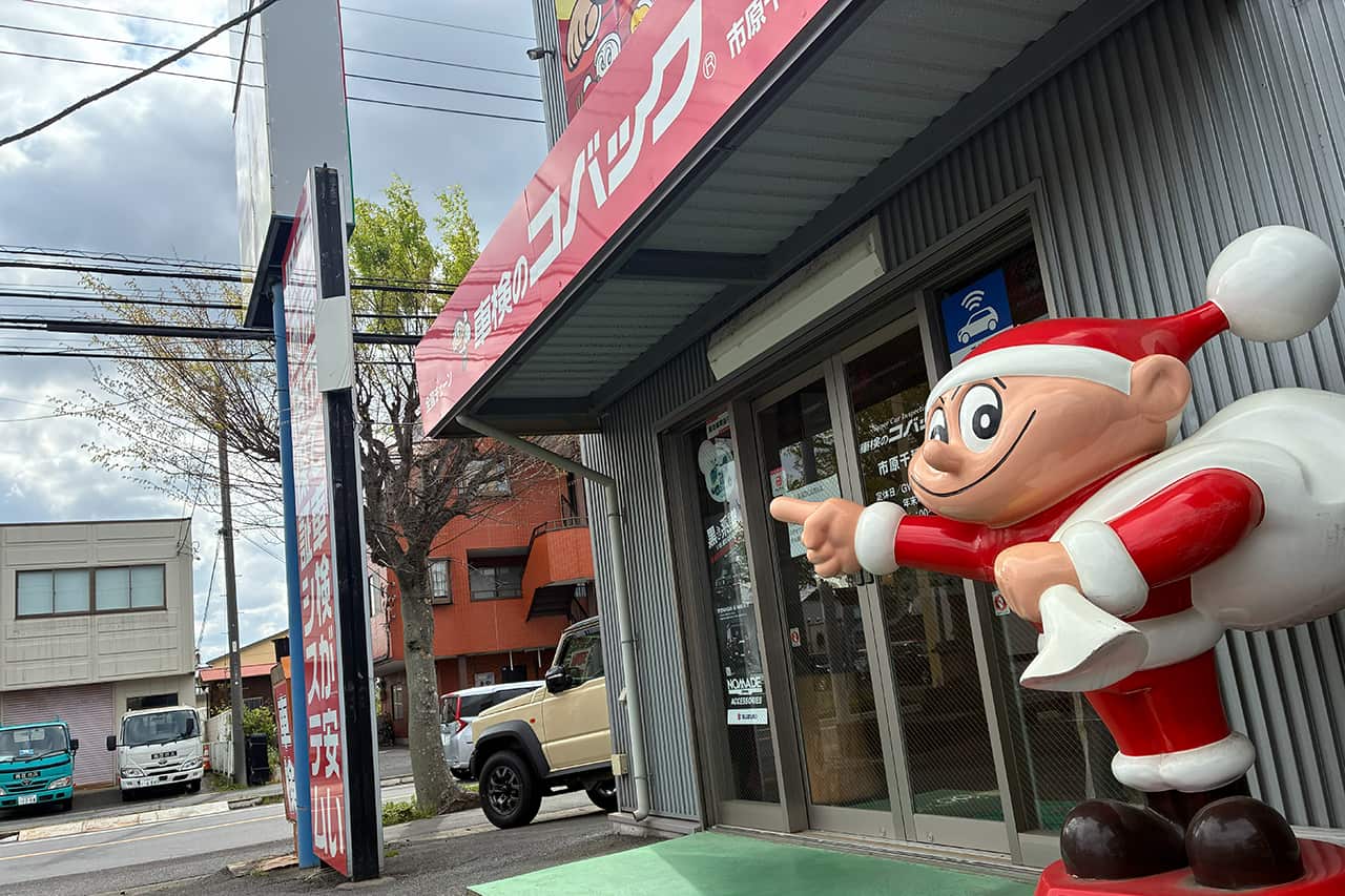 コバックの看板と店舗入り口に立つマスコットキャラクター